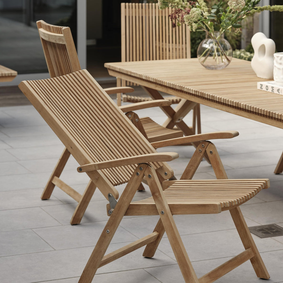 Brafab Julita spisestol med armlene i teak ved spisebord på terrasse