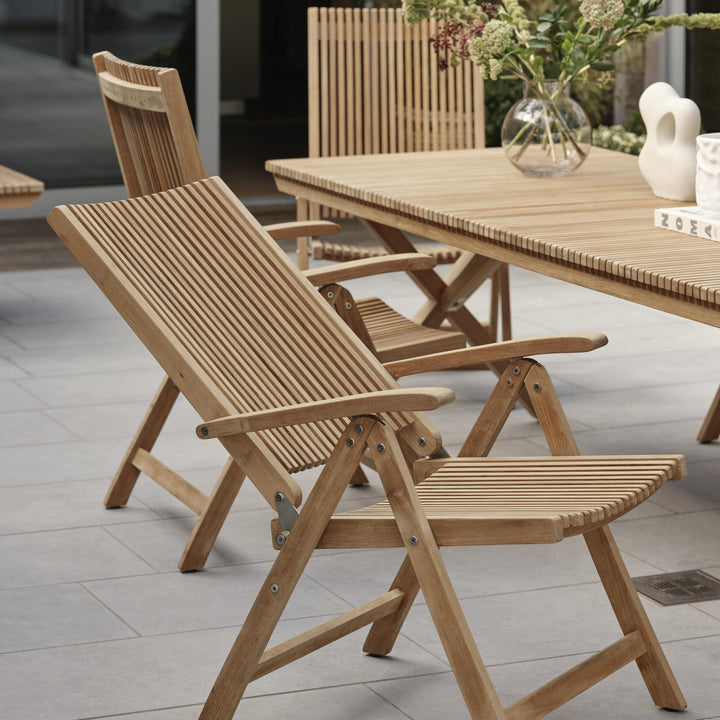 Brafab Julita spisestol med armlene i teak ved spisebord på terrasse