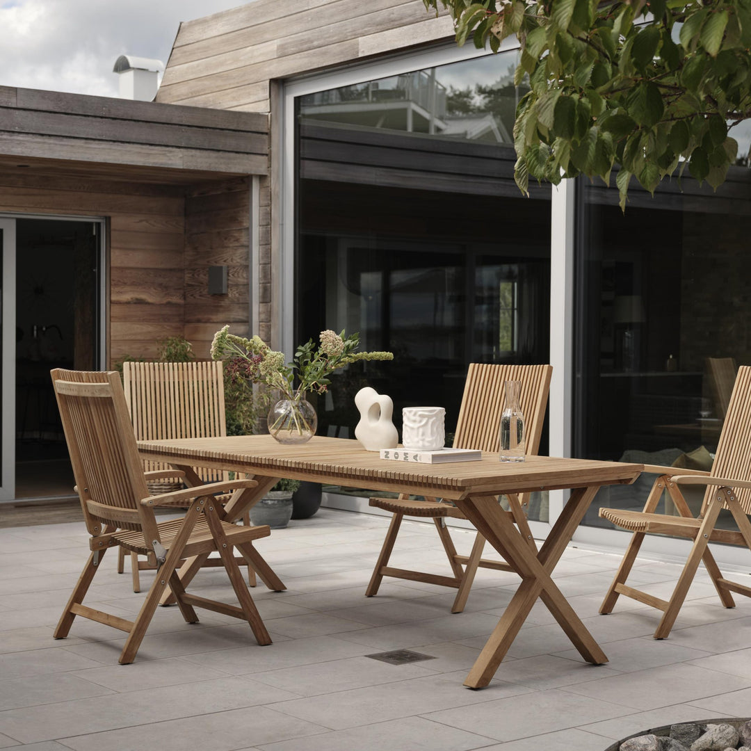 Brafab Julita spisestoler med armlene i teak rundt spisebord ved moderne hus