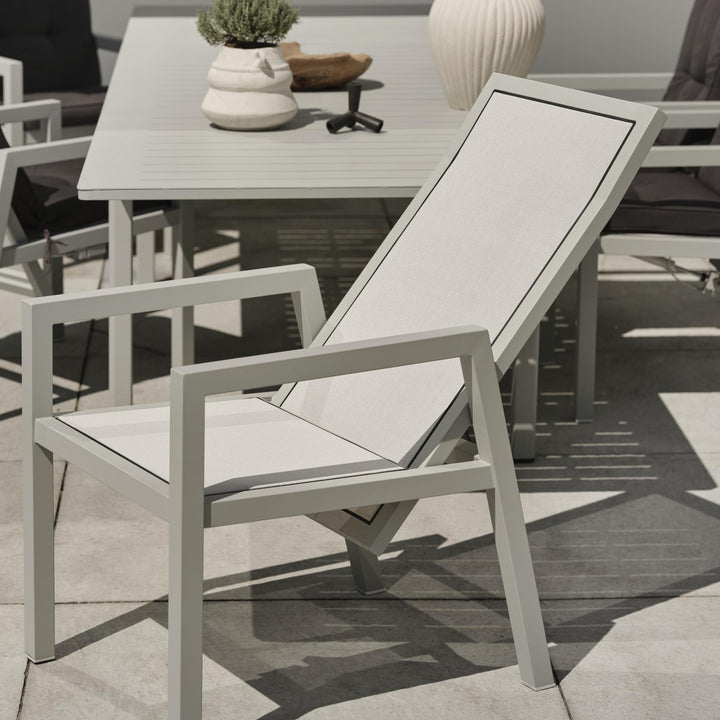 Brafab Newfort spisestol med lys grå sling, tilbakelent ved hagebord med vase og lavendel på terrasse