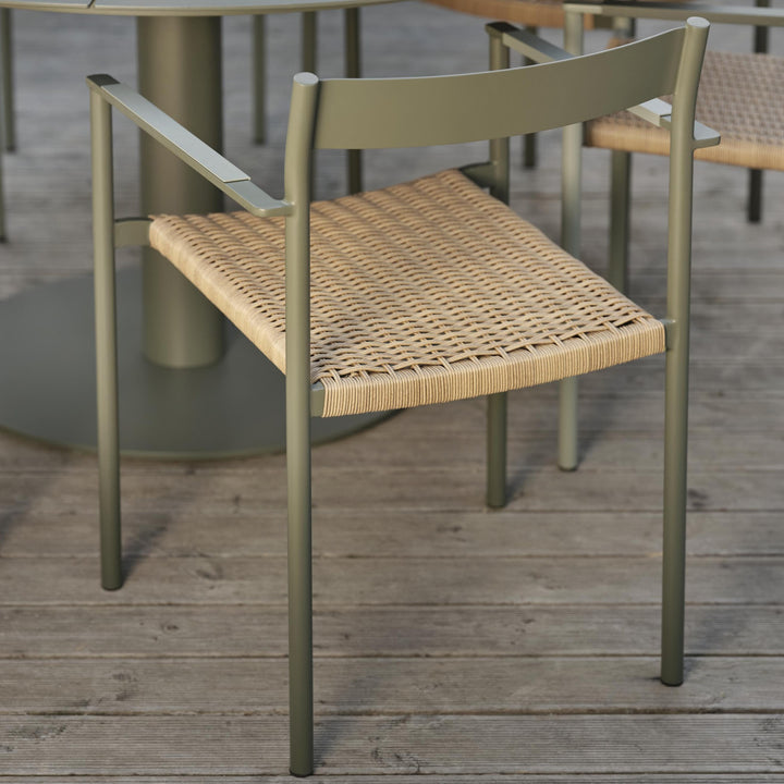 Brafab DK spisestol i nordic green med flettet natursete, ved bord på tredekk ute