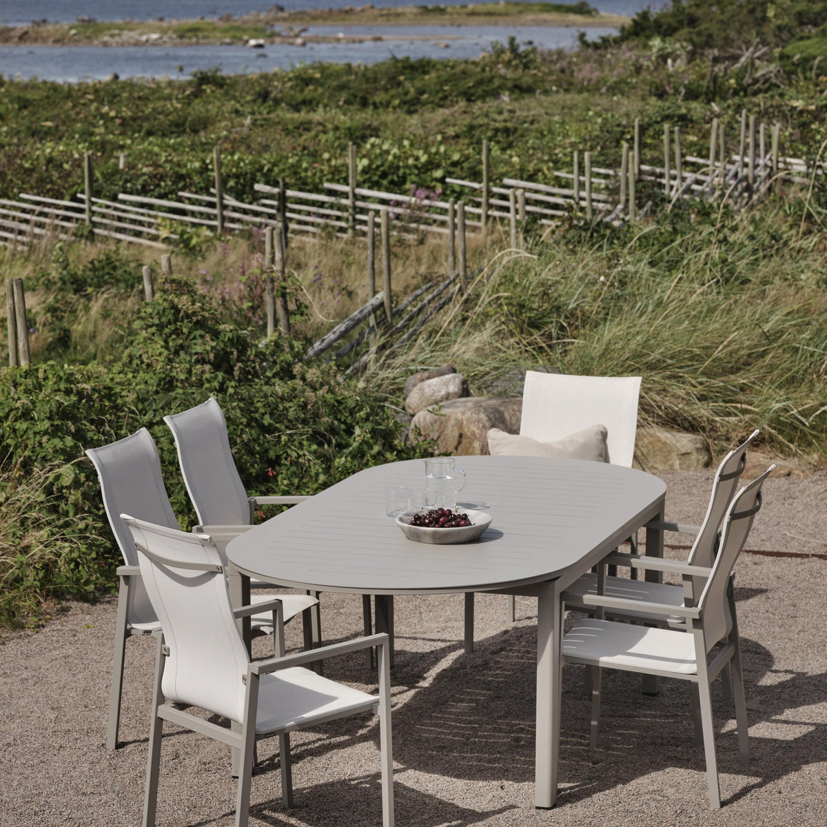 Brafab Comfy spisestoler i offwhite rundt beige spisebord ved kysten