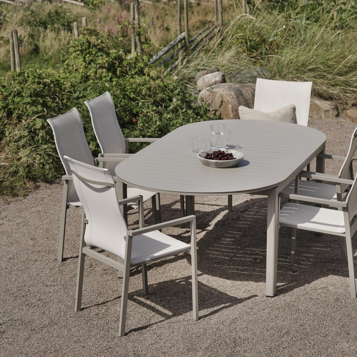 Brafab Comfy spisestoler ved beige spisebord på grusplass ved kysten