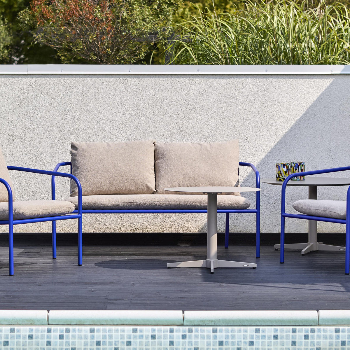 Brafab Bendt hagestol med blå ramme og beige puter på terrasse med basseng