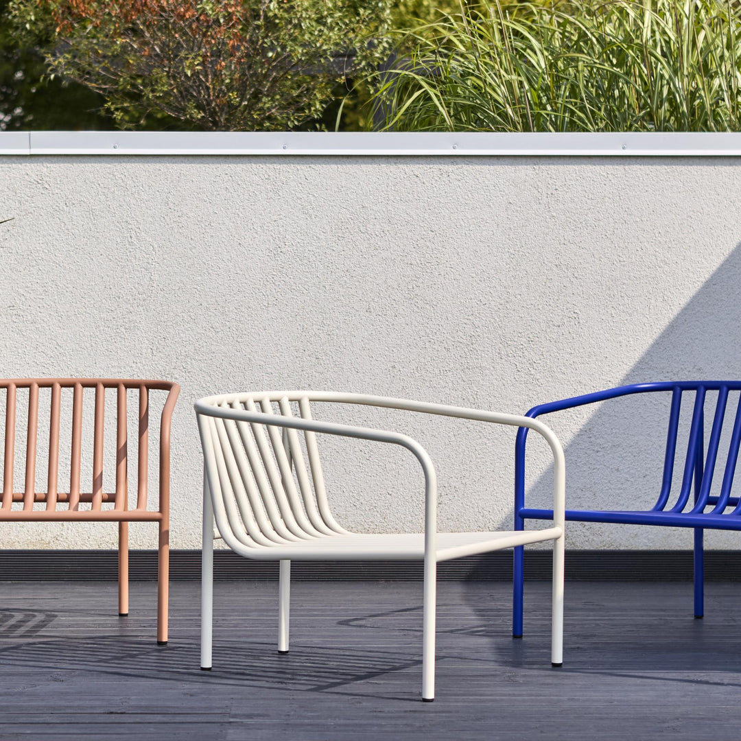 Brafab Bendt hagestol i offwhite på terrasse, flankert av fersken og blå stol med planter