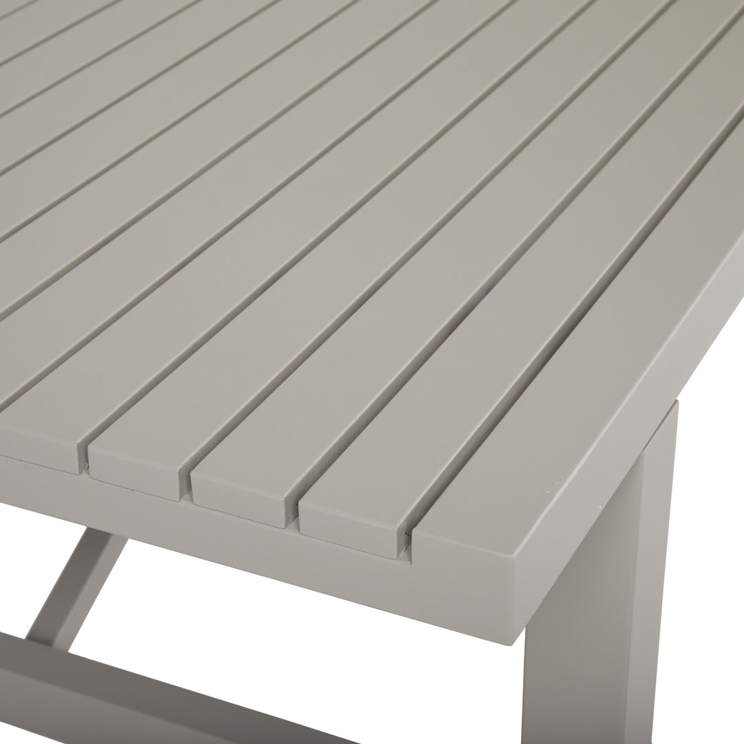 Brafab Vevi spisebord i lys gråbeige aluminium, nærbilde av spaltet bordplate og bordben mot lys bakgrunn