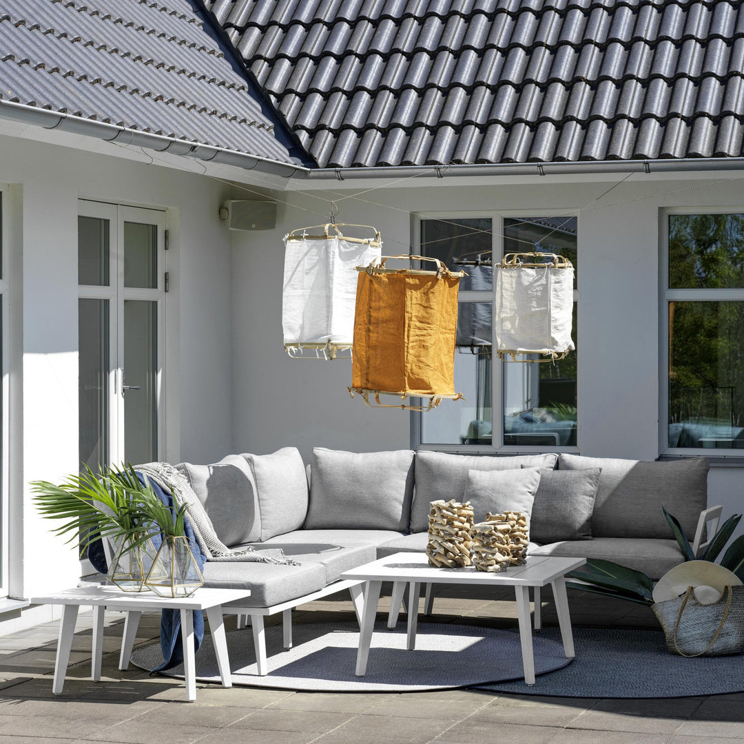 Brafab Villac sofabord i hvit foran grå hjørnesofa på terrasse, med puter og lyslykter