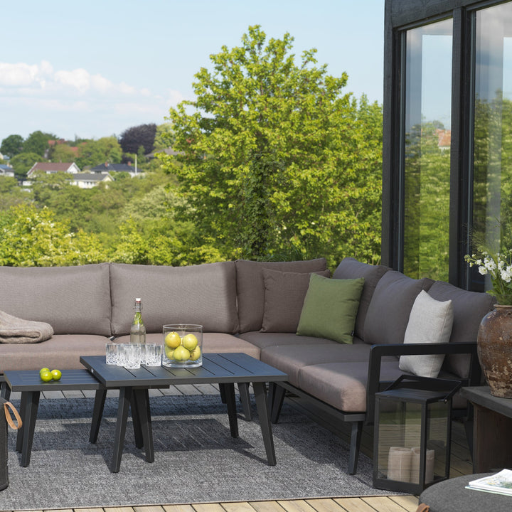 Brafab Villac sofabord i mørk grå med spileplate ved hjørnesofa med beige puter på takterrasse.