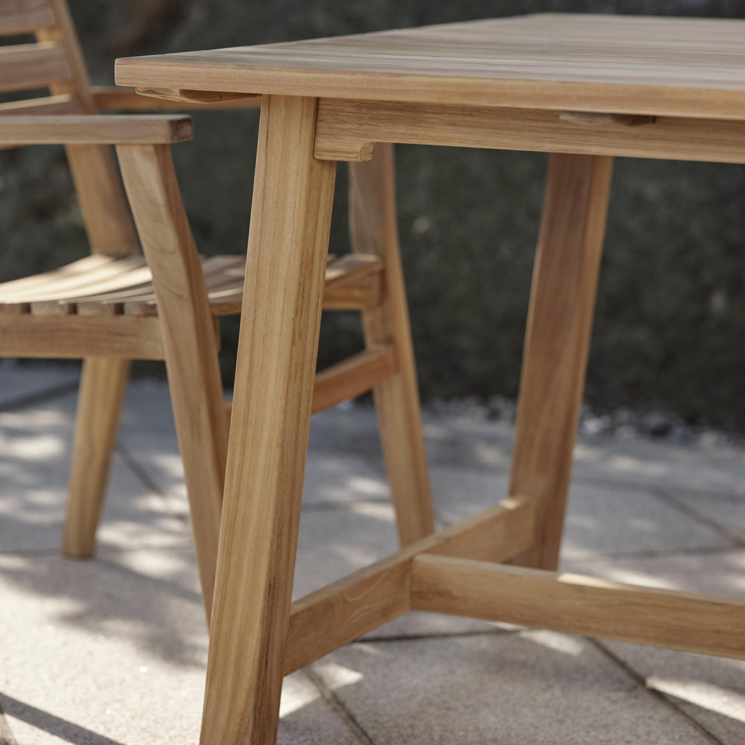 Brafab Keros spisebord i teak, nærbilde av bordhjørne og bein på terrasse