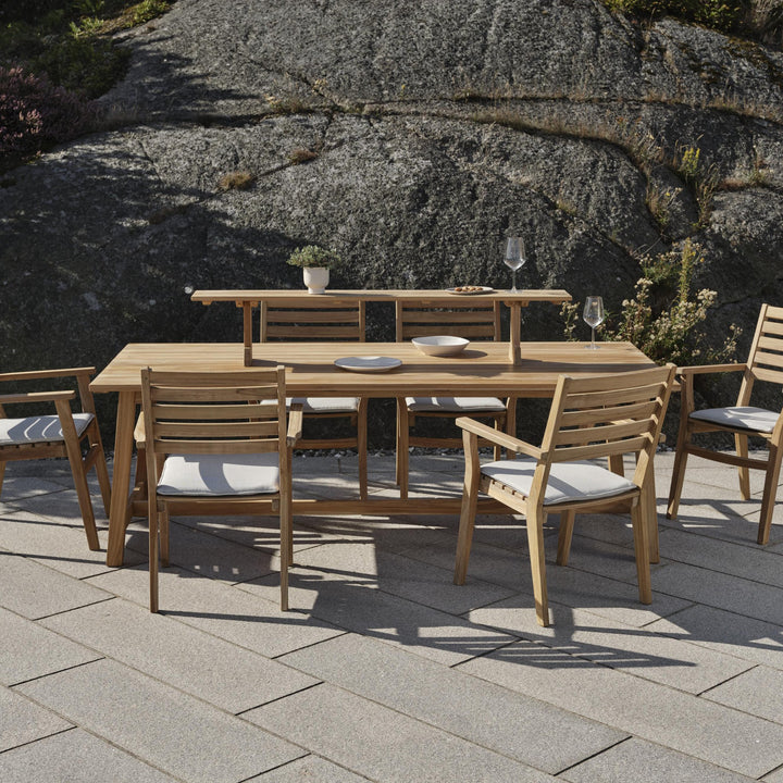Brafab Keros spisebord i teak med stoler på terrasse foran fjellknaus