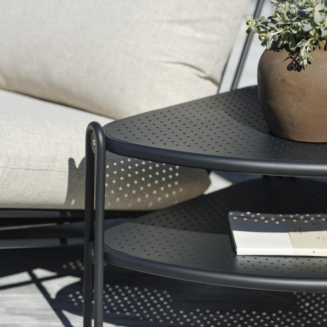 Brafab Blixt sofabord i sort perforert metall med plante, ved beige sofa