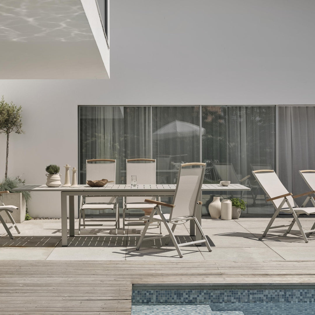 Brafab Lomma spisebord i khaki på terrasse ved basseng med posisjonsstoler og oliventre