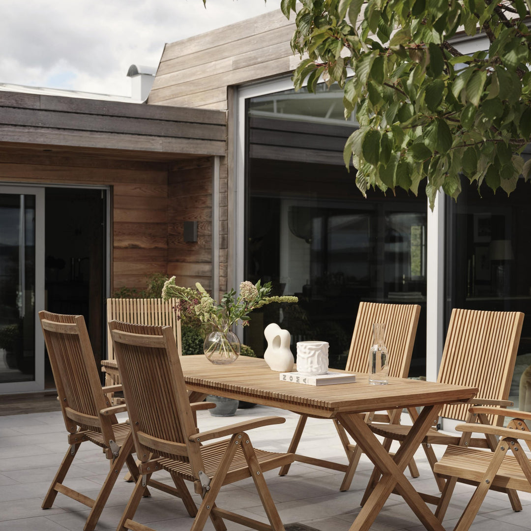 Brafab Julita spisebord i teak med stoler på terrasse foran trekledd hus