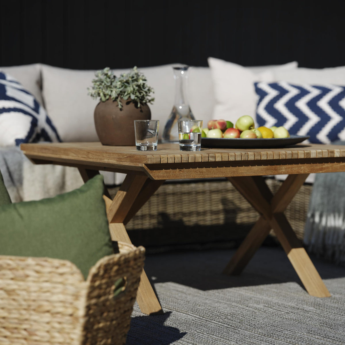 Brafab Julita sofabord i natur teak med eplefat, karaffel og plante på terrasse