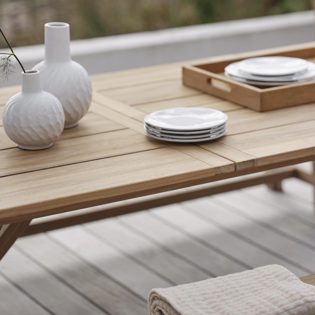 Brafab Brutus spisebord i lys natur teak, nærbilde av plate med hvite vaser og servise