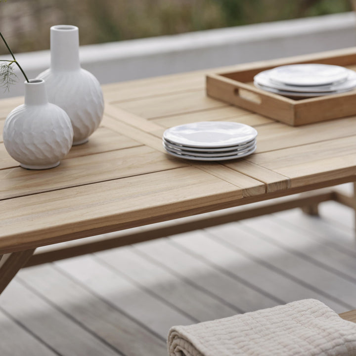 Brafab Brutus spisebord i lys natur teak, nærbilde av plate med hvite vaser og servise