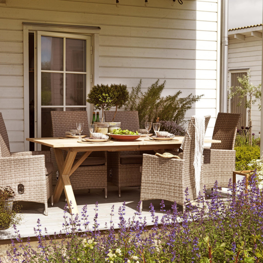 Brafab Brutus spisebord i lys natur teak med rottingstoler på terrasse med lavendel