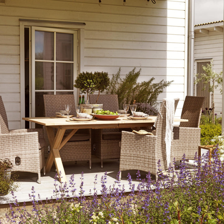 Brafab Brutus spisebord i lys natur teak med rottingstoler på terrasse med lavendel