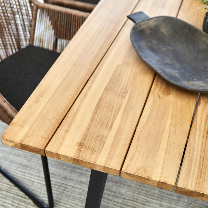 Brafab Laurion spisebord i teak med sort fat, nærbilde av planker og brun taustol