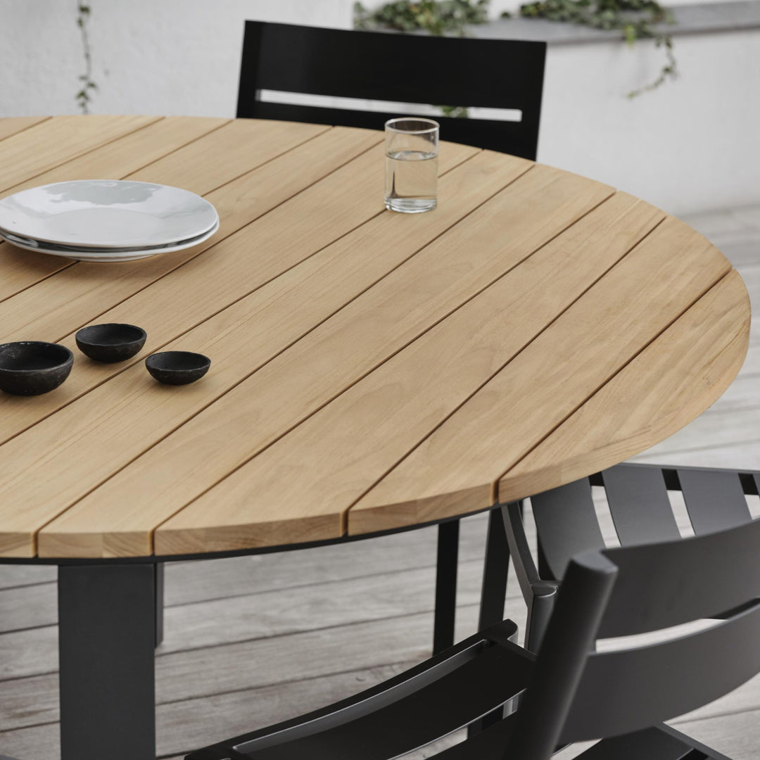 Brafab Laurion rundt spisebord i natur teak med sort understell og stol, dekket