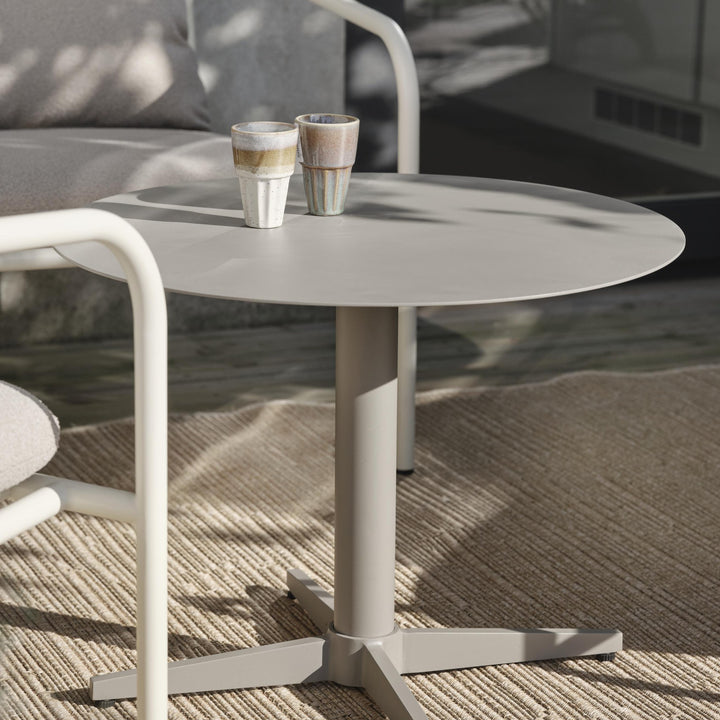 Brafab Mill sofabord i gråbeige metall på terrasse med jutematte og to keramikkopper