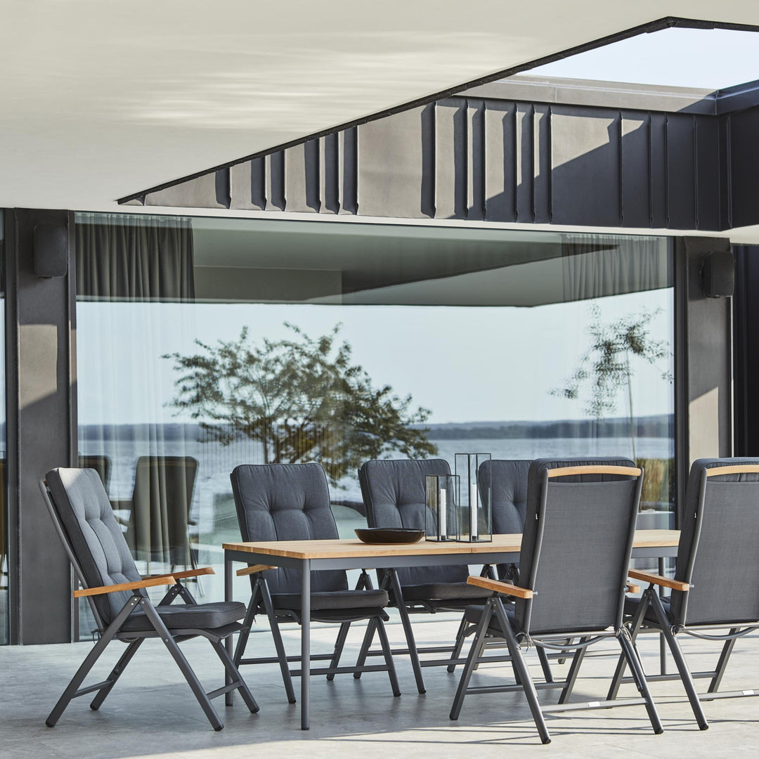 Nox Bamboo spisebord i lys grå med hvite stoler, dekket bord med vase og grener på terrasse