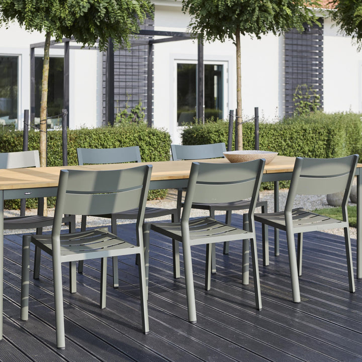 Brafab Nox Bamboo spisebord med treplate og grønne stoler på mørk terrasse ved hvitt hus