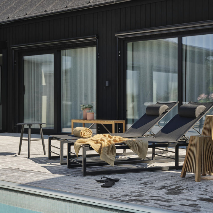 Brafab Julita lampeskjerm i teak med spiler, på terrasse ved basseng med solsenger