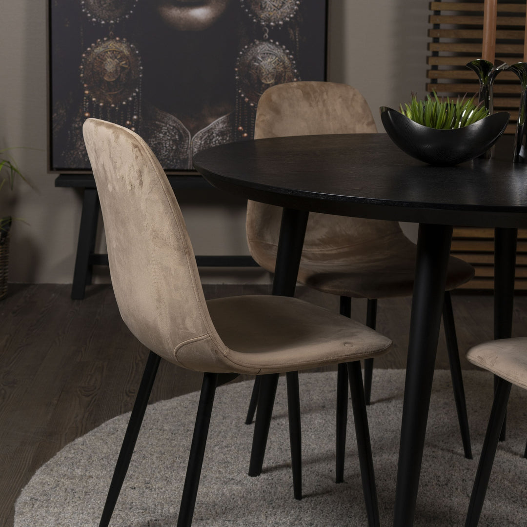 Trend spisestoler i beige velur rundt sort spisebord, med planter og veggbilde