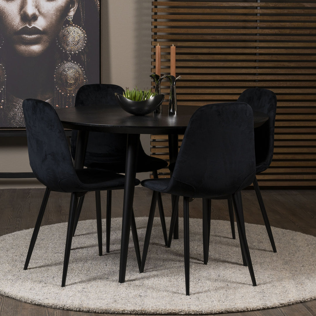 Trend spisestol i sort velur med sorte ben ved rundt sort spisebord på lyst teppe