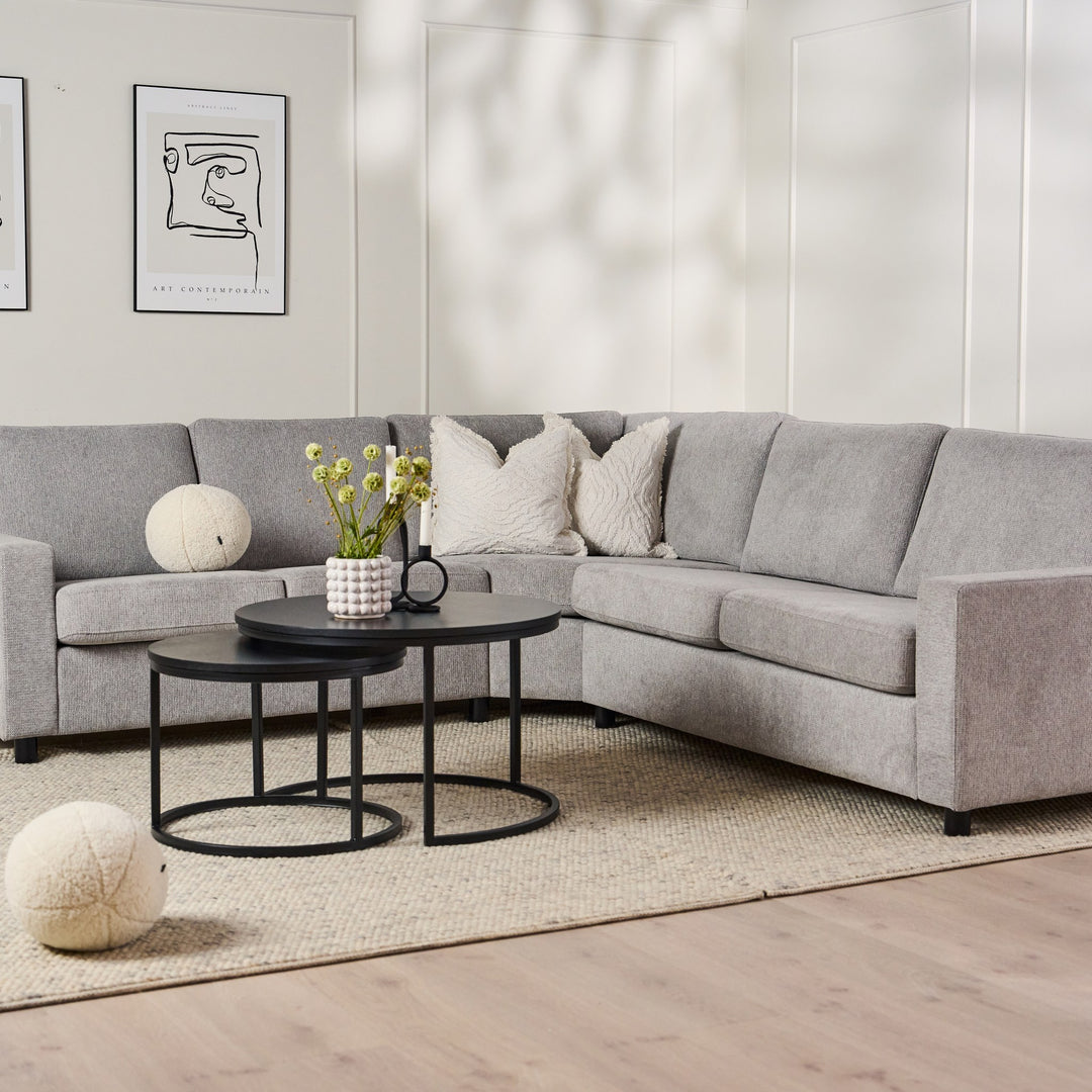 Metro sofabord rundt i sort eikefinér med sort metallring foran grå sofa