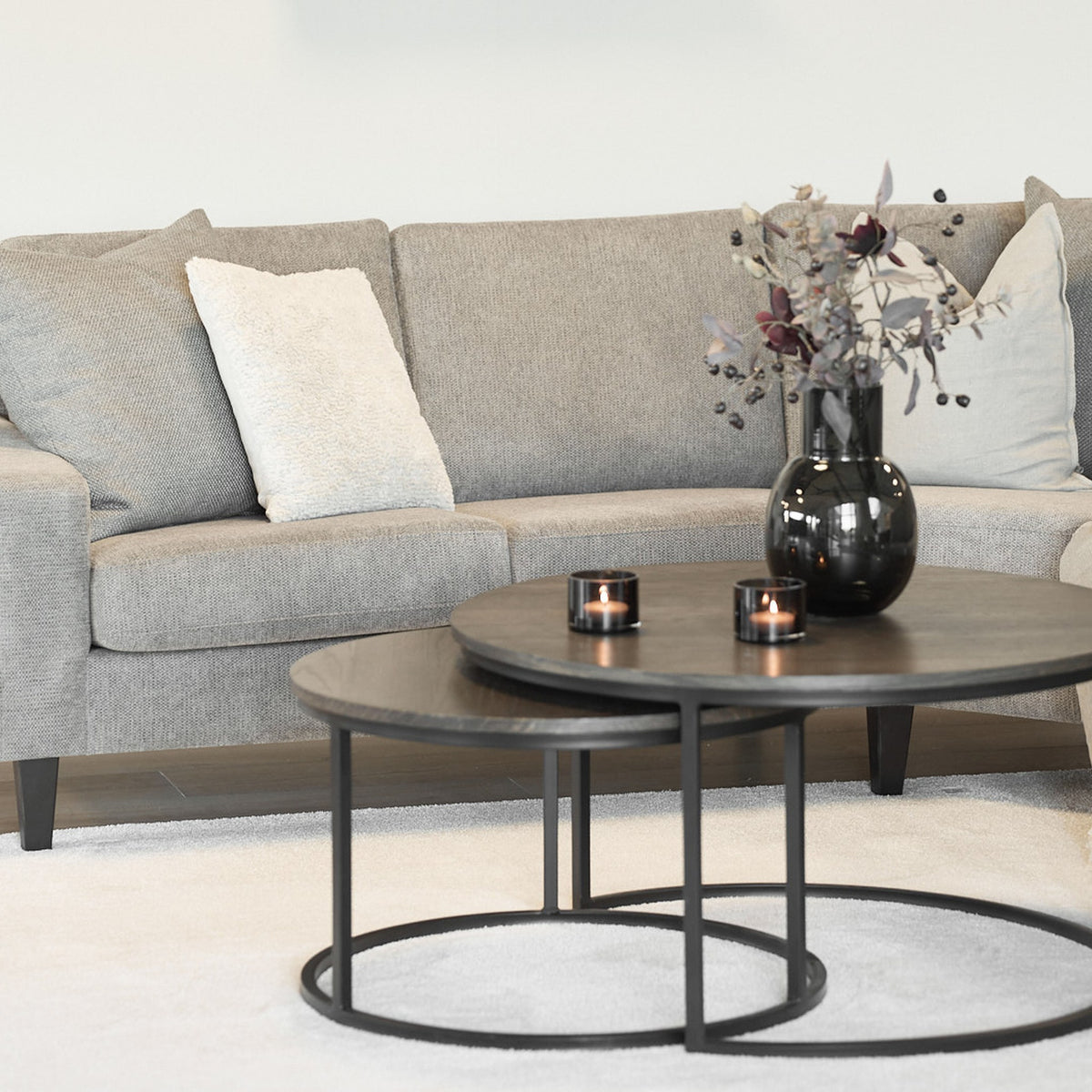 Metro sofabord i røkpigmentert eik med sort metallring foran beige sofa