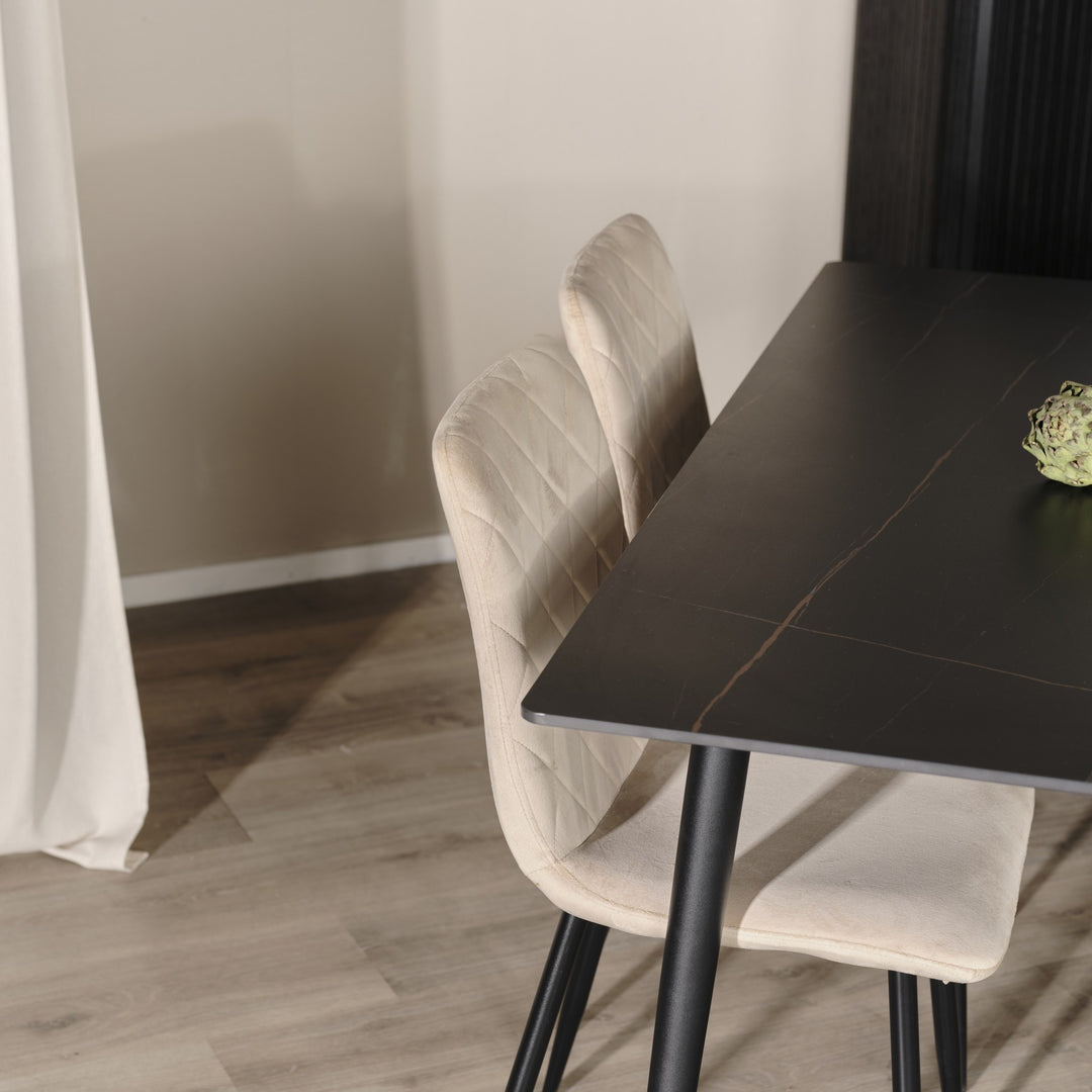 Bari spisestol i beige velour med sorte ben ved et sort marmorert spisebord