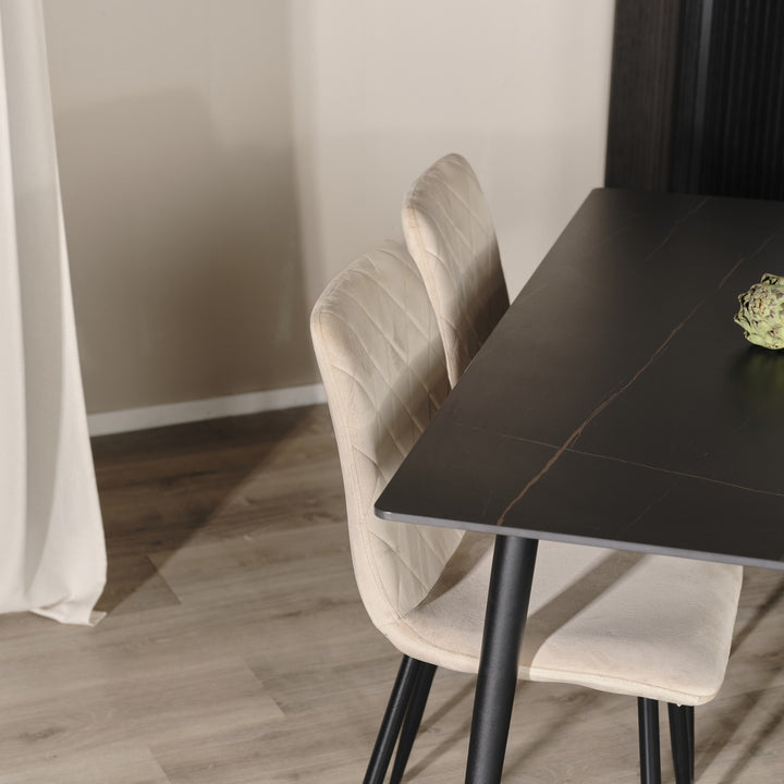 Bari spisestol i beige velour med sorte ben ved et sort marmorert spisebord