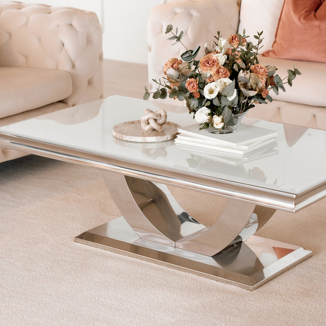 Firenze sofabord med lys glassplate og buet kromfot foran beige chesterfieldsofa