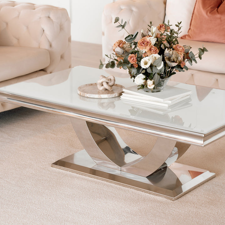 Firenze sofabord med lys glassplate og buet kromfot foran beige chesterfieldsofa