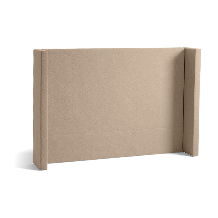 Svane Monaco sengegavl i varm beige bouclé med polstrede sidekanter.