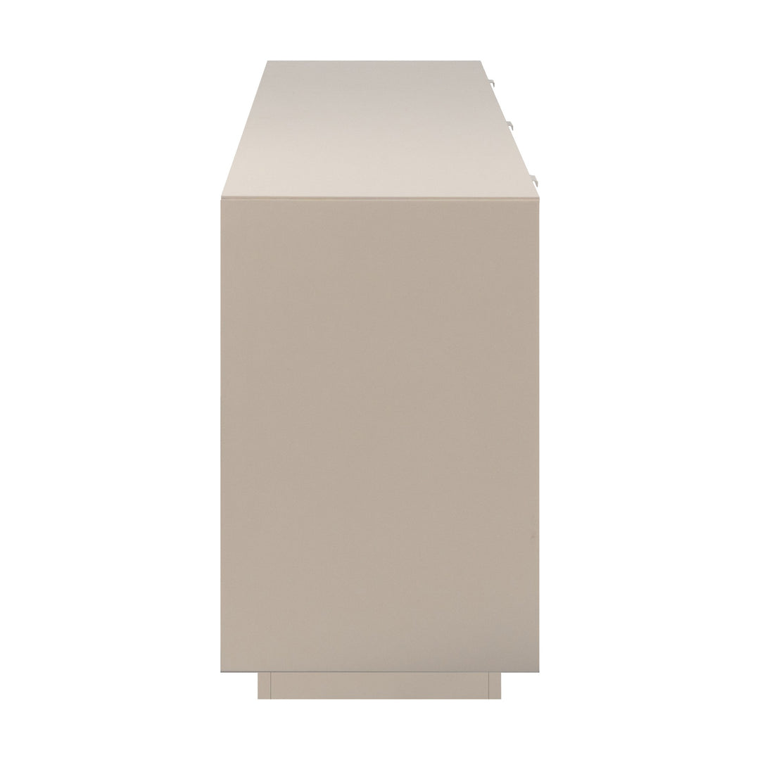 Sivas tv-benk i beige sett fra siden, viser glatt sidepanel og lav sokkel, mot lys bakgrunn.