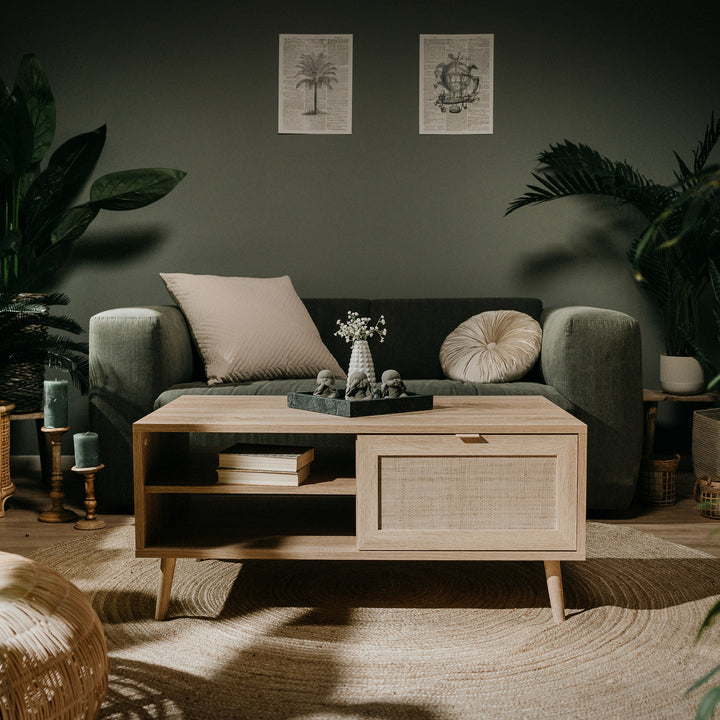 Bali sofabord i lys eik med rottingskuff, i stue med grønn sofa og planter