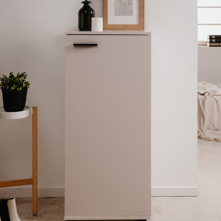 Satos skoskap i beige i lyst rom med vase og plante ved siden