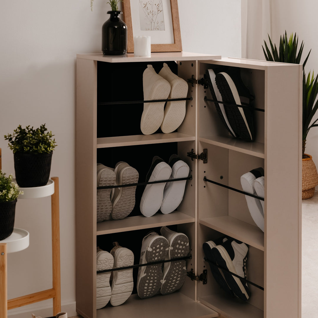 Satos skoskap i beige med åpne dører og skråhyller fulle av sko, i lyst rom med grønne planter