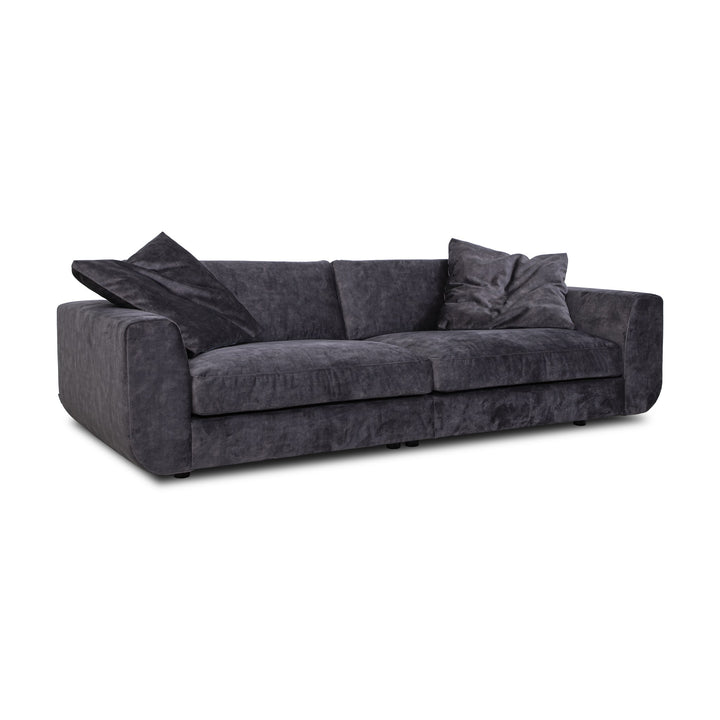 Motive sofa i koksgrå velur med løse puter, sett skrått forfra