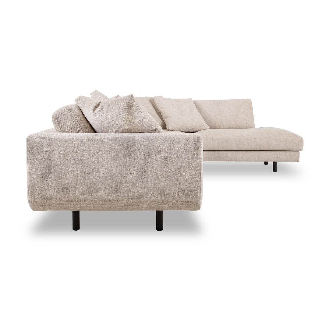 Lazy hjørnesofa i sandfarget chenille, sett fra siden med løse puter