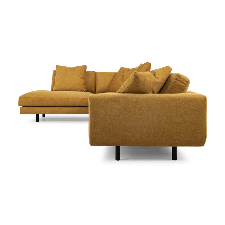 Lazy hjørnesofa i karrigul chenille, sett fra siden med løse puter