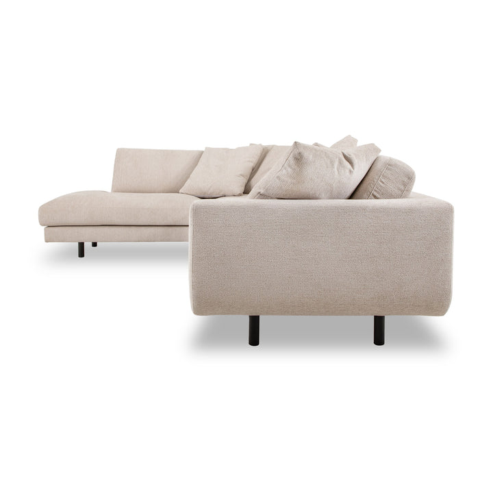 Lazy hjørnesofa i sandfarget chenille, sett fra siden med løse puter