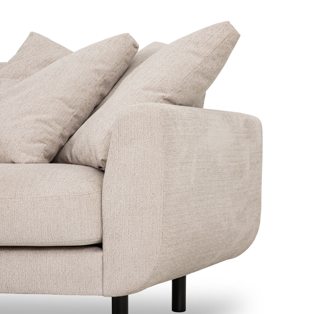 Lazy Sofa i lys beige stoff, nærbilde av armlene, ryggputer og svart ben