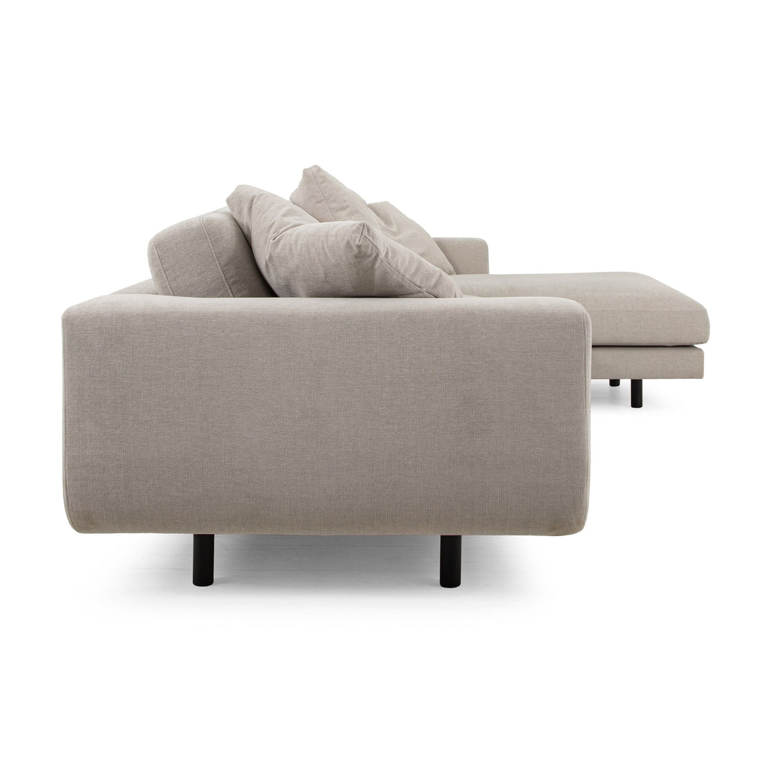 Lazy Sofa i kremhvitt stoff sett fra siden, med sjeselong og svarte ben