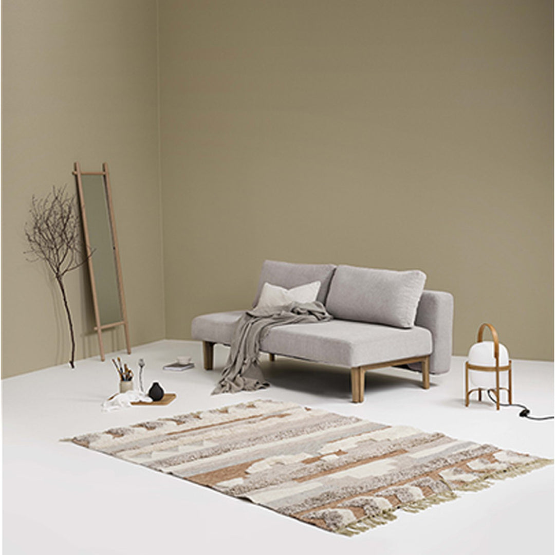 Hovden Sleepy sovesofa i grå i beige rom med speil, teppe og lampe