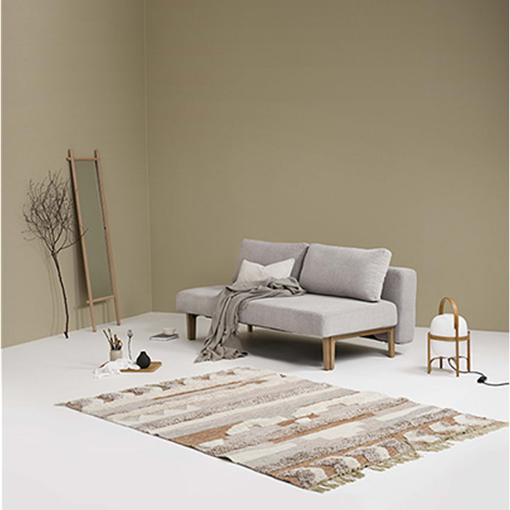 Hovden Sleepy sovesofa i grå i beige rom med speil, teppe og lampe