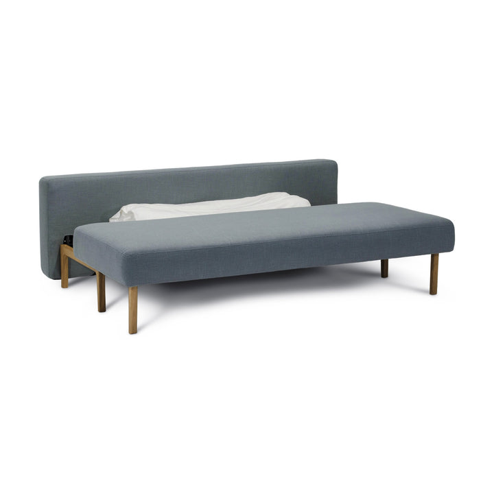 Hovden Sleepy sovesofa i gråblå, utfelt til seng med sengetøy, hvit bakgrunn